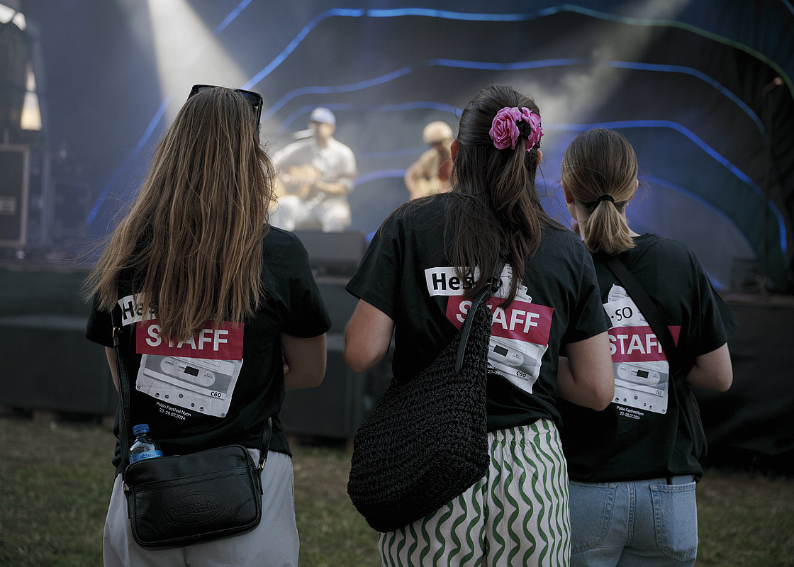 trois étudiantes avec le t-shirt staff HES-SO à Paléo devant la scène Face Nord